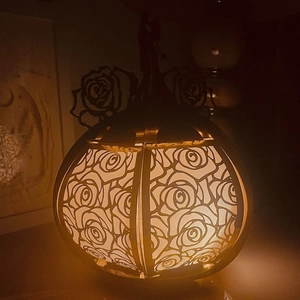 Detailed view of hollow rose pattern lantern with warm glowing light for festive decor