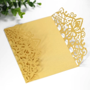 Detail of laser-cut floral pattern on golden pearlescent wedding invitation sleeve