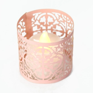 Detail of pink laser-cut hollow paper lampshade with warm LED electronic candle light
