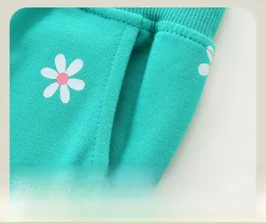 Détail du jogging vert menthe pour enfant avec imprimé marguerites et poches latérales