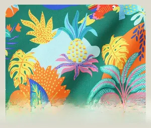 Close-up of tropical dinosaur fabric with vibrant parrot and pineapple patterns