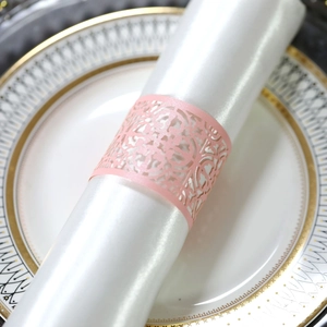 Detail eines rosa laserggeschnittenen Serviettenrings aus Papier mit Blumenmuster