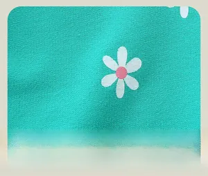 Gros plan détaillé des motifs marguerites sur le pantalon de sport vert pour filles