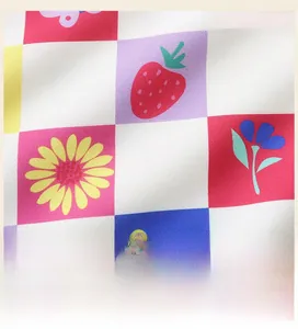 Detail view of the girls sweatshirt featuring colorful strawberry and daisy checkered print