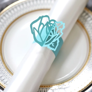 Detailed view of blue laser-cut rose napkin ring on a white elegant dinner plate