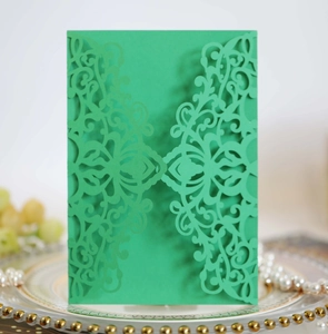 Detailed laser-cut floral pattern on vibrant green wedding invitation cardstock cover