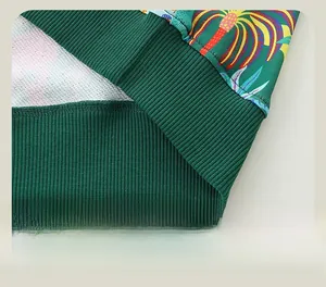 Detailed macro view of the dark green tropical print sweatshirt featuring ribbed hem design