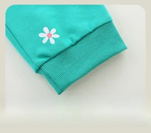 Détail du jogging bleu sarcelle avec bords-côtes élastiques et imprimés marguerites