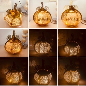 Detail of gold hollow pumpkin lantern with rose patterns and romantic couple silhouette