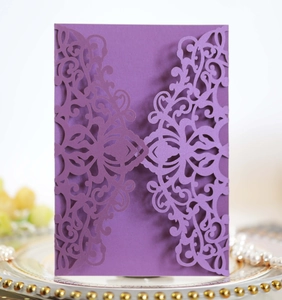 Detail of purple laser-cut wedding invitation sleeve with intricate floral pattern