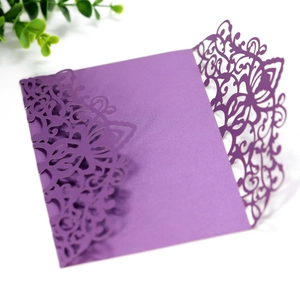 Close-up of elegant purple laser-cut wedding invitation with intricate floral hollow design