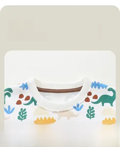 Détail du col rond côtelé avec motifs de dinosaures colorés sur ce sweat-shirt pour garçon