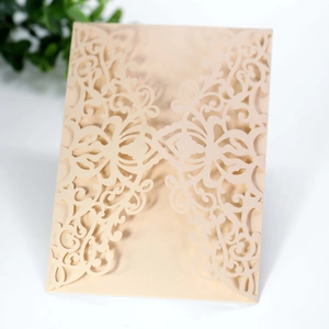 Detailed laser-cut pattern on champagne wedding invitation envelope with floral motifs