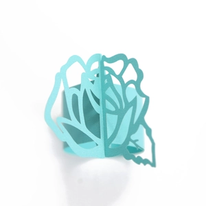 Detail of laser-cut paper napkin ring with elegant light blue rose flower design