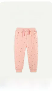 Detail of pink cotton joggers for girls featuring an all-over red cherry print design
