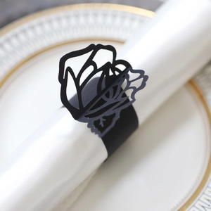Detailed laser-cut rose design on a matte black napkin ring with elegant floral patterns