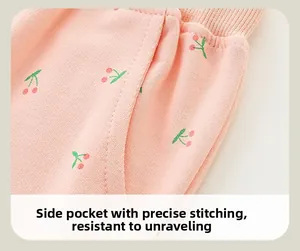 Detail of pink girls' joggers with cherry print, side open pocket, and durable stitching