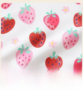 Détail de l'imprimé fraise et fleurs sur tissu blanc pour sweat-shirt de fille