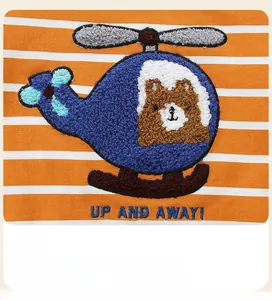 Detail der Hubschrauber-Stickerei und des Bären auf gestreiftem Kinderpullover in Orange