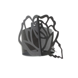 Detailed view of a black laser-cut hollow rose flower napkin ring for wedding table decor