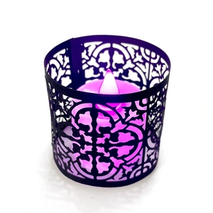 Detail of laser-cut black lampshade with purple LED candle light for holiday decor