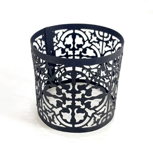 Detail showing the intricate laser-cut floral pattern on a black decorative candle sleeve