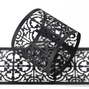 Detail of black laser-cut hollow card with elegant European classical scroll pattern