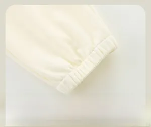 Macro detail of elastic ribbed cuffs on cream-colored knitted children's sports pants