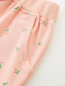 Pink girl's joggers with cherry print, ribbed waistband and pockets in soft cotton