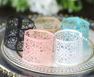 Detailed laser-cut hollow pattern on colorful paper napkin rings for elegant dining
