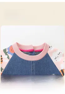 Close-up of pink ribbed neckline and denim fabric with sun and bee embroidery