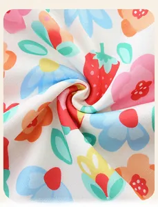 Close-up of soft knitted white fabric with strawberry and flower print for girls