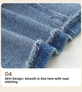 Detailed close-up of blue denim A-line hemline with raw edges and neat stitching