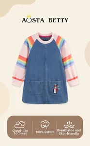 Detail of soft 100% cotton denim girls dress featuring rainbow sleeves and penguin embroidery