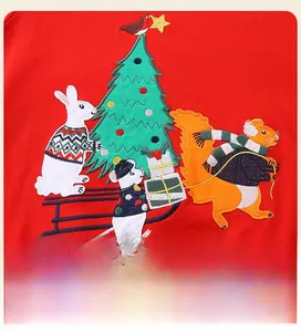 Gros plan sur les broderies de Noël avec lapin et écureuil sur sweat en coton rouge