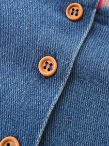 Denim dress for girls with brown wooden buttons and a soft pink knit lining detail