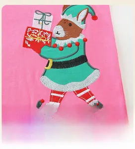 Dettaglio dell'abito in maglia rosa con ricamo di un coniglio di Natale per bambine