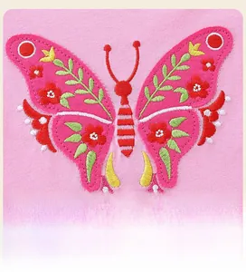 Detail of butterfly embroidery with floral patterns on pink girls long sleeve dress