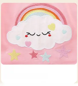 Detail of high-quality rainbow and smiley cloud embroidery on pink girls' knit dress