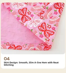 Detailed close-up of pink A-line dress hem with butterfly embroidery and fine stitching