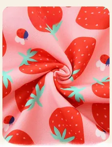 Dettaglio del morbido tessuto a maglia rosa con graziose stampe di fragole e coccinelle
