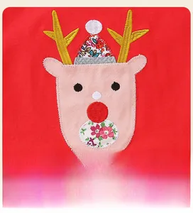 Détail rapproché d'une broderie de renne de Noël sur une robe de fête rouge en tulle