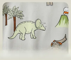 Detail of dinosaur and volcano cartoon prints on soft grey knit cotton fabric