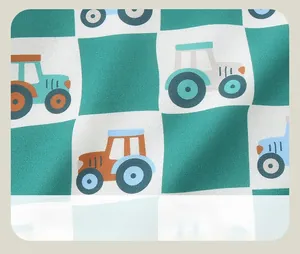 Detail of green and white checkerboard fabric with colorful cartoon tractor patterns