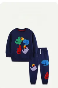 Detail of blue cotton boy tracksuit featuring colorful cartoon dinosaur towel embroidery