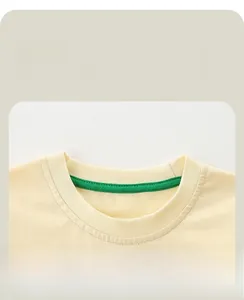 Détail du col d'un t-shirt enfant jaune crème avec bande de propreté verte robuste