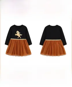 Detail of girls mesh princess dress with golden horse print and layered orange tulle