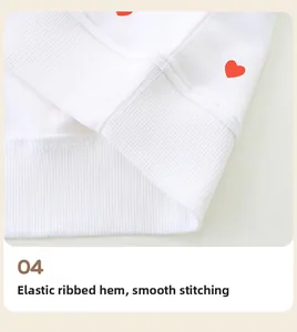 Detail of white cotton sweatshirt featuring a red heart print and ribbed elastic hem