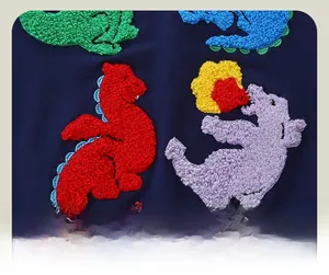 Detail of colorful dinosaur towel embroidery on navy blue boys' sweatshirt fabric