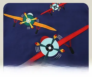 Gros plan détaillé de la broderie avion sur le tissu du sweat en coton bleu foncé
